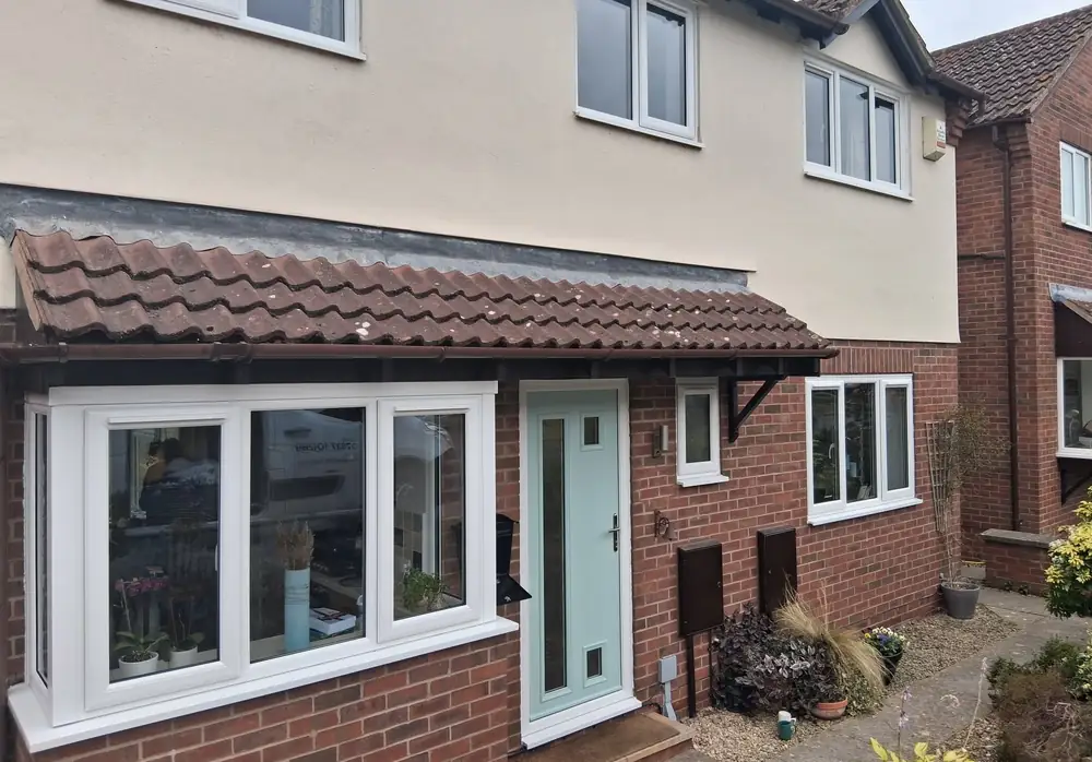 A house in Ross-on-Wye with a new white uPVC bow window, a pale green composite front door and white uPVC windows upstairs